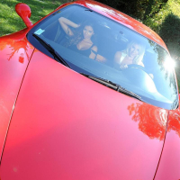 Danielle Maye and Krystal Webb screw in a Ferrari