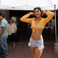 Latina Reina Rae poses wearing denim shorts and sexy top
