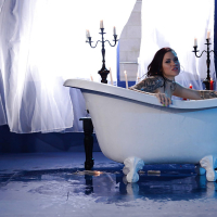 Tattooed babe Karmen Karma spreading wet pussy in candle lit bathtub