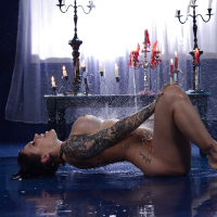 Tattooed babe Karmen Karma spreading wet pussy in candle lit bathtub