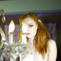 Redhead doxy Dani Jensen takes off her top and poses in ripped pantyhose
