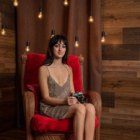 Corinna Kay showing her small boobs and shaved pussy on a chair