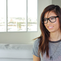 Nerdy amateur babe Kimberly Costa posing solo on couch in yoga pants