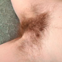Franckoh is laying in bed in her pink dress and showing off her hairy pits and legs She has white panties that cover her hairy bush and is feeling horny She strips nude and rolls around naked in bed
