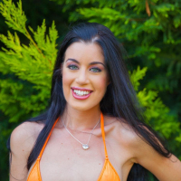 Gorgeous April Blue posing in an orange bikini outdoors