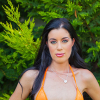 Gorgeous April Blue posing in an orange bikini outdoors