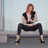 Redhead babe Lilith Lust flashes her crotch tatoo outside