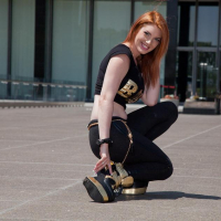 Redhead babe Lilith Lust flashes her crotch tatoo outside