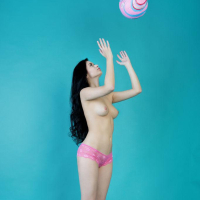 Pretty girl Carmen Summer plays with her ball in the studio