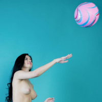 Pretty girl Carmen Summer plays with her ball in the studio
