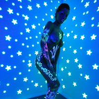 Angel Dark has her sexy booty and tits prettified with glowing bodyart