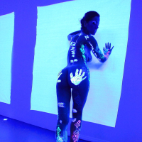 Angel Dark has her sexy booty and tits prettified with glowing bodyart