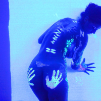 Angel Dark has her sexy booty and tits prettified with glowing bodyart