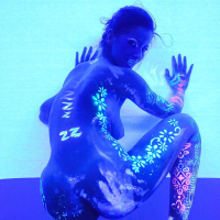 Angel Dark has her sexy booty and tits prettified with glowing bodyart