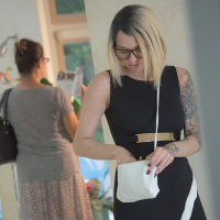 Tattooed female Emma Mae revealing bald vagina underneath black dress
