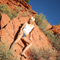 Graceful blonde Emma Mae stripping off her top and panties outdoor