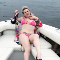 Curvy Emmy Demure posing in a pink bikini on the boat