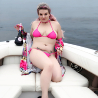 Curvy Emmy Demure posing in a pink bikini on the boat