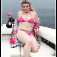 Curvy Emmy Demure posing in a pink bikini on the boat