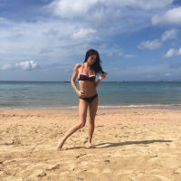 Gorgeous girl Lovenia Lux posing in a black bikini on the beach