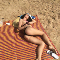 Gorgeous girl Lovenia Lux posing in a black bikini on the beach