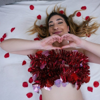 Lexi Grey lays on the bed with rose petals