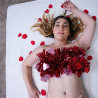 Lexi Grey lays on the bed with rose petals