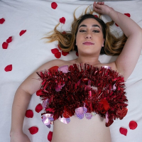 Lexi Grey lays on the bed with rose petals