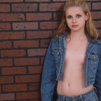 Petite teen Lil Candy strips her jean jacket to reveal her small tits