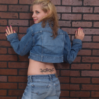 Petite teen Lil Candy strips her jean jacket to reveal her small tits