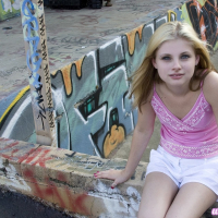 Cute Lil Candy poses outdoors with graffiti and gets horny