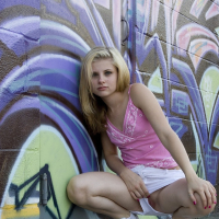 Cute Lil Candy poses outdoors with graffiti and gets horny