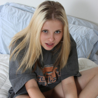 Pretty Lil Candy poses in a grey tshirt before fingering her tight pussy