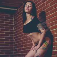 Tattooed babe Jessica Alvarez unveils her tits while posing
