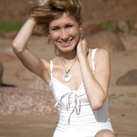 Lovely young girl Mariana strips and shows her shaved pussy on the beach