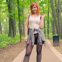 Redhead Jeny Smith posing outdoors in Nylons