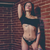 Stunning tattooed Latin teen is stripping and teasing in the bedroom