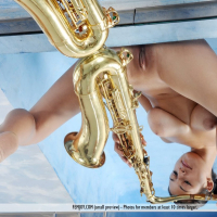 Busty Femjoy Sofie posing naked with a Saxophone
