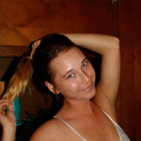 Brunette Renee Wilson having fun doing striptease and showing her tits