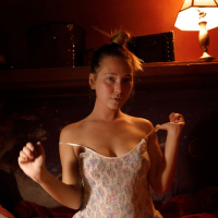 Brunette Renee Wilson having fun doing striptease and showing her tits