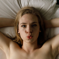 Solo Minka Giertz with natural tits and hot ass posing naked on the bed