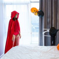 Eva Tender posing in a sexy devil costume in the bedroom