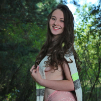 Anna Bella poses naked on a blanket in the park