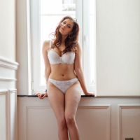 Sexy brunette Amelie Belain posing naked by the window