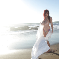 Buxom pornstar Tessa Fowler modeling topless outdoors on beach
