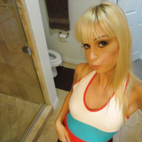Blond chick Erica Fontes taking selfies in mirror while taking off her clothes