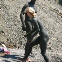 Real nudist couple taking mud bath