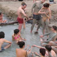 Group of young nudists taking mud bath