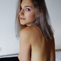 Platinum blonde teen Eva Elfie fingers her horny pussy atop her bed