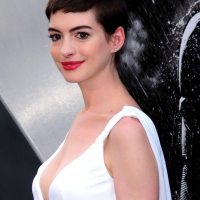 Anne Hathaway showing cleavage in white dress at Dark Knight Rises premiere in